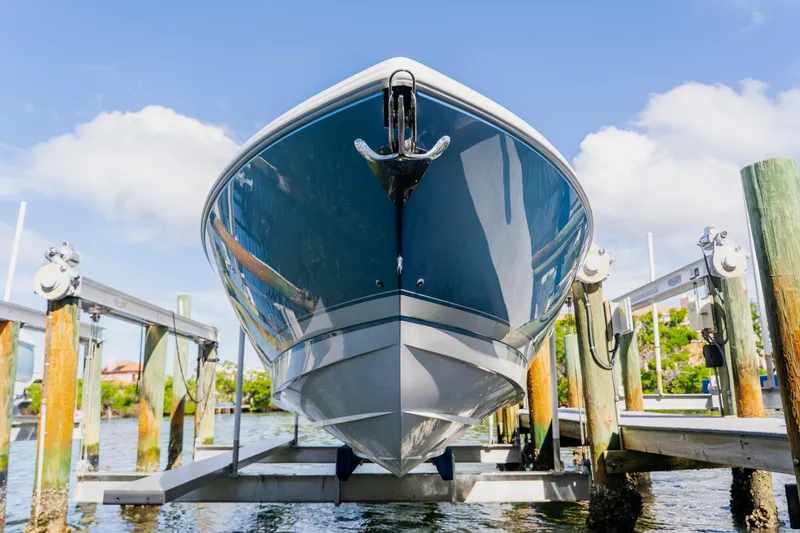 Slide: The Image of 2018 Intrepid 327 Center Console boat on lift, sunny day, waterfront view. - 106