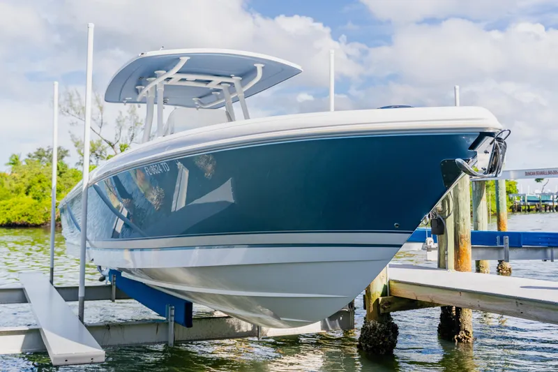 Slide: The Image of 2018 Intrepid 327 Center Console boat docked on a lift by the water. - 107