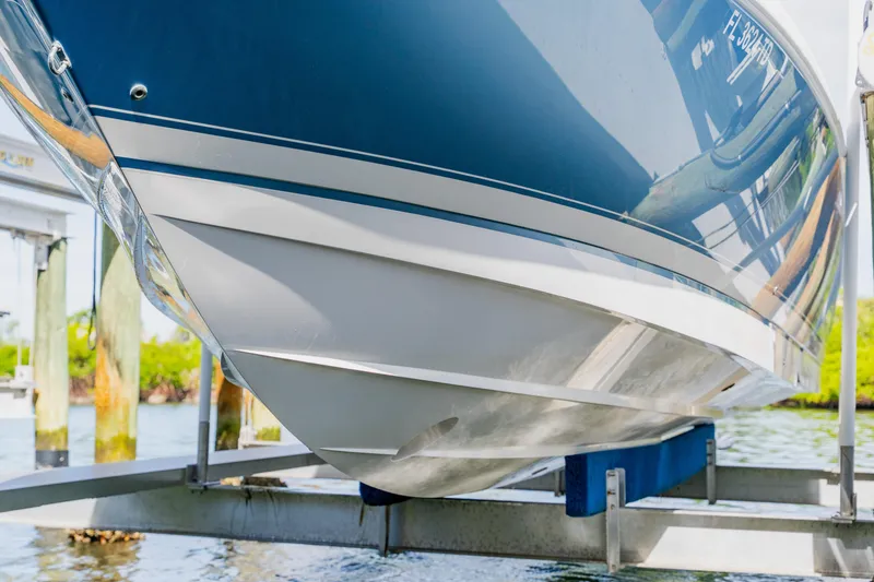 Slide: The Image of 2018 Intrepid 327 Center Console boat on lift, showcasing sleek hull design. - 108