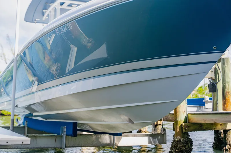 Slide: The Image of 2018 Intrepid 327 Center Console boat on lift, blue and white hull. - 109