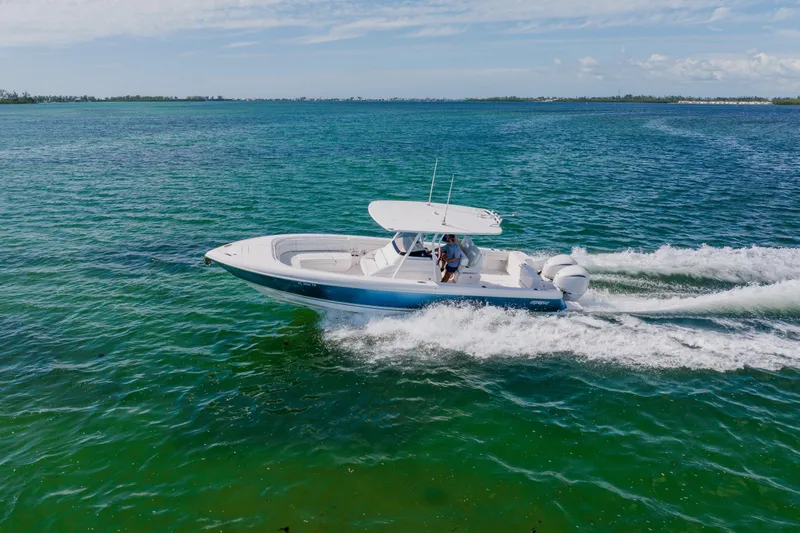 Slide: The Image of 2018 Intrepid 327 Center Console boat cruising on clear blue water. - 13