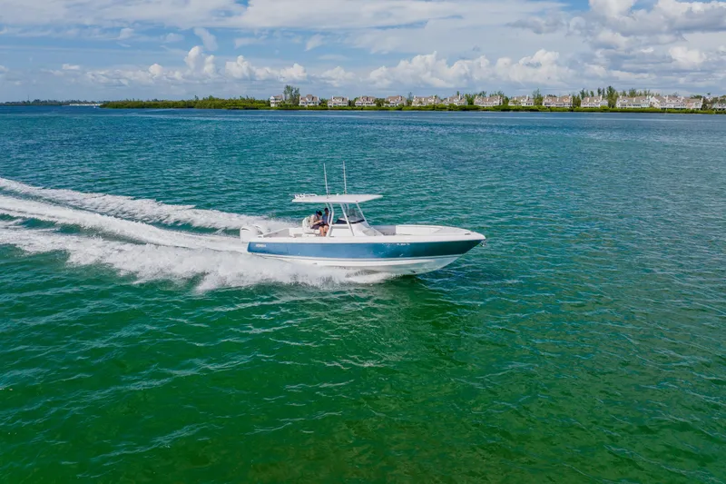 Slide: The Image of 2018 Intrepid 327 Center Console boat cruising on clear blue water. - 15