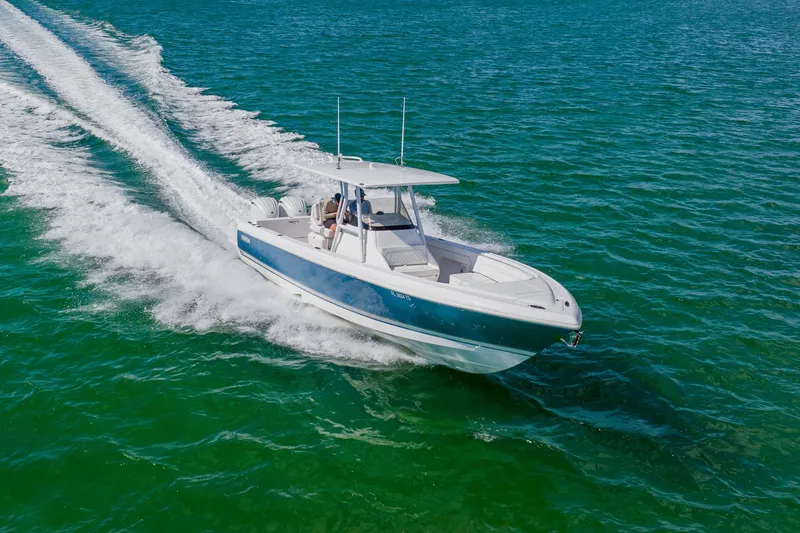Slide: The Image of 2018 Intrepid 327 Center Console boat cruising on clear blue water. - 16