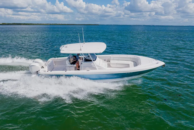 Slide: The Image of 2018 Intrepid 327 Center Console boat cruising on open water under a clear sky. - 20