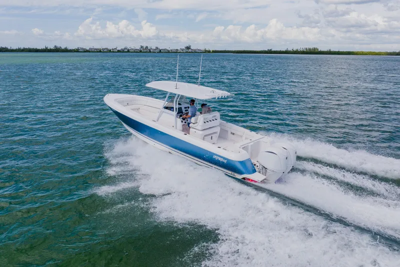 Slide: The Image of 2018 Intrepid 327 Center Console boat cruising on open water, creating a wake. - 22