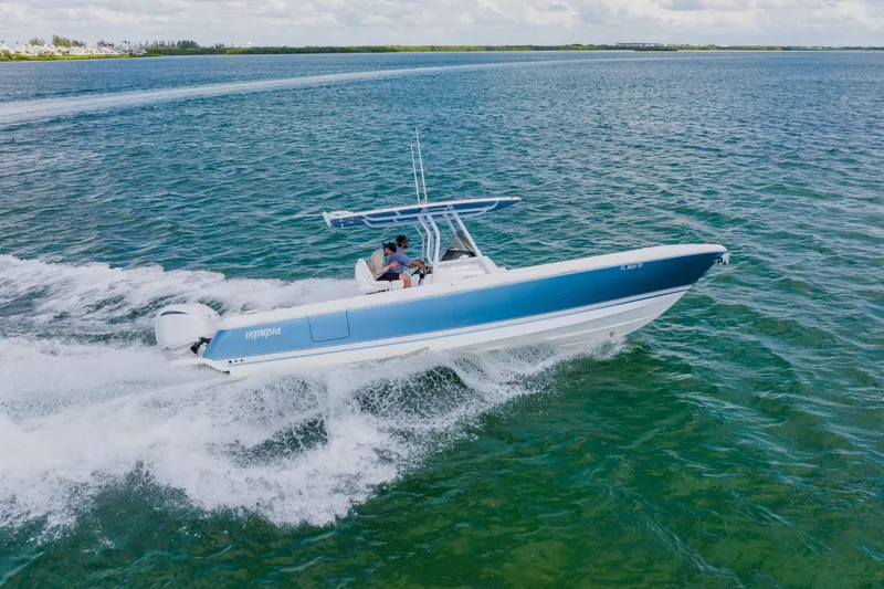 Slide: The Image of 2018 Intrepid 327 Center Console boat cruising on clear blue water. - 27