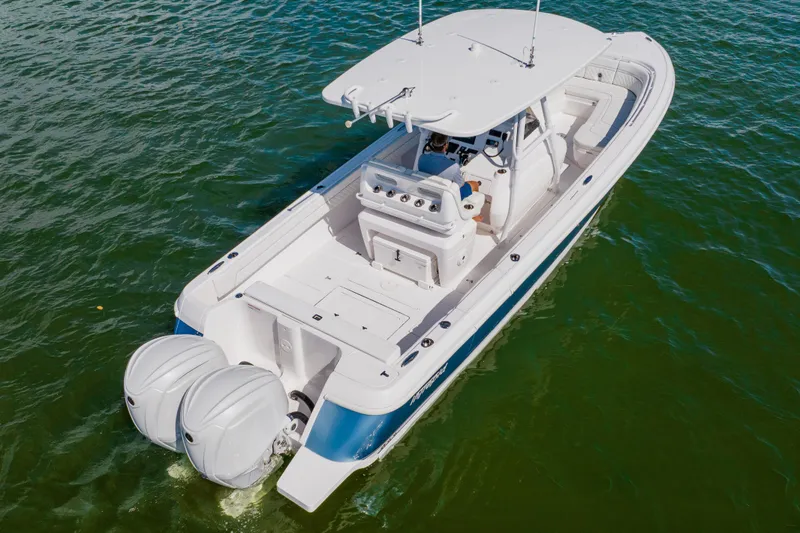 Slide: The Image of 2018 Intrepid 327 Center Console boat on water, featuring dual outboard engines. - 3