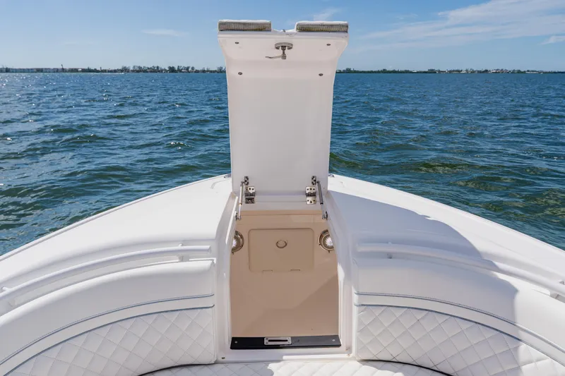 Slide: The Image of 2022 Intrepid 327 Center Console boat with open storage compartment on calm water. - 31