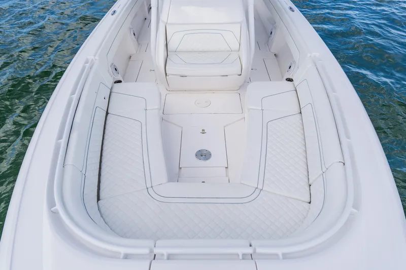 Slide: The Image of 2018 Intrepid 327 Center Console boat interior with white cushioned seating on water. - 33