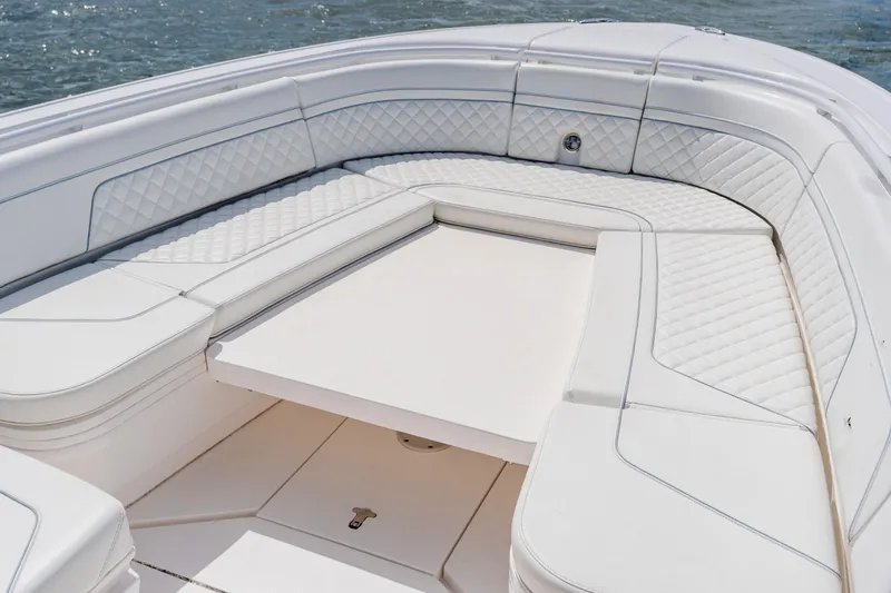 Slide: The Image of 2018 Intrepid 327 Center Console boat with luxurious white seating and table. - 36