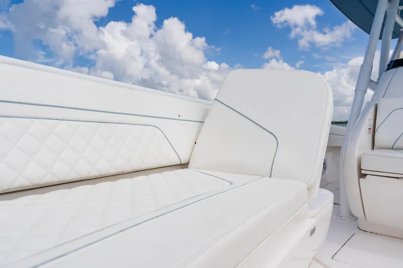 Slide: The Image of 2018 Intrepid 327 Center Console boat with luxurious white seating under a blue sky. - 39