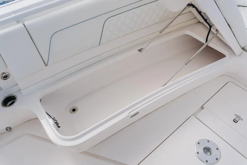 Slide: The Image of 2018 Intrepid 327 Center Console boat storage compartment with open lid and hydraulic supports. - 47