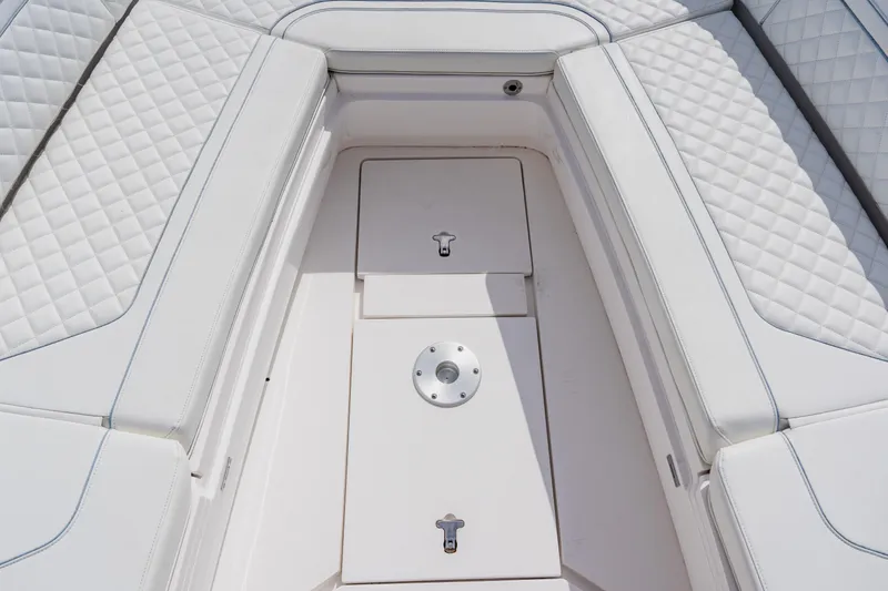 Slide: The Image of 2018 Intrepid 327 Center Console boat interior with quilted white seating and storage compartments. - 50