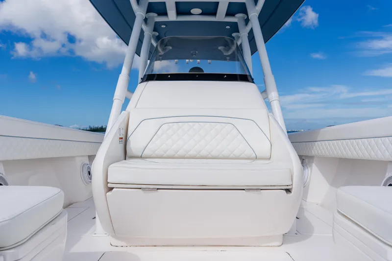 Slide: The Image of 2018 Intrepid 327 Center Console boat interior with white seating and blue sky background. - 53