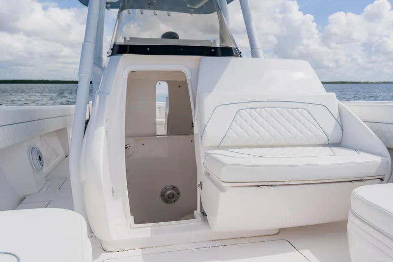 Slide: The Image of 2018 Intrepid 327 Center Console interior with white seating and open cabin door. - 55