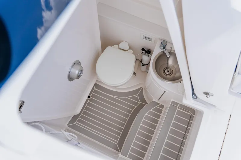 Slide: The Image of 2018 Intrepid 327 Center Console boat bathroom with toilet and sink. - 56