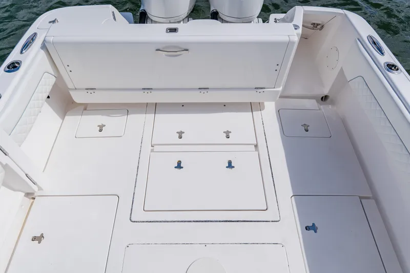 Slide: The Image of 2018 Intrepid 327 Center Console boat deck with storage compartments and seating. - 80