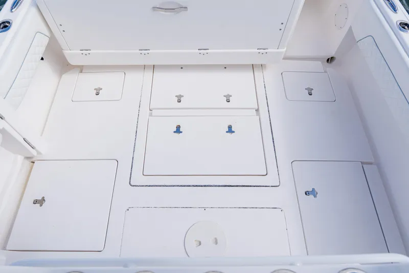 Slide: The Image of 2018 Intrepid 327 Center Console boat deck with multiple storage compartments. - 82