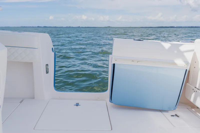 Slide: The Image of 2018 Intrepid 327 Center Console boat with open hatch, overlooking calm sea. - 84