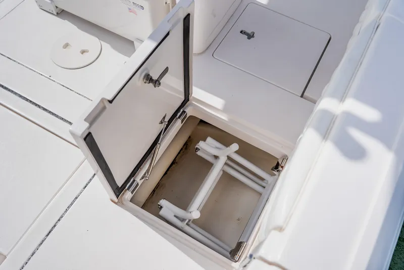 Slide: The Image of Open storage compartment on 2018 Intrepid 327 Center Console boat deck. - 85