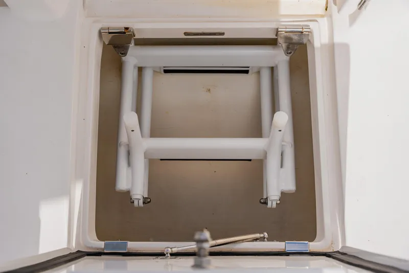 Slide: The Image of Storage compartment of 2018 Intrepid 327 Center Console boat, featuring a foldable ladder. - 86