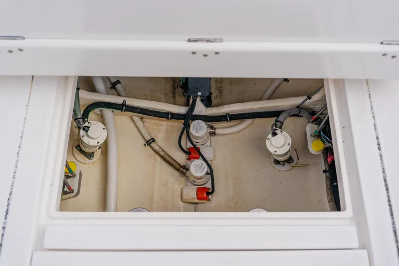 Slide: The Image of 2018 Intrepid 327 Center Console bilge area with pumps and hoses visible. - 92