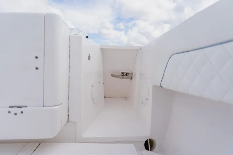 Slide: The Image of 2018 Intrepid 327 Center Console interior detail with white seating and storage compartment. - 98