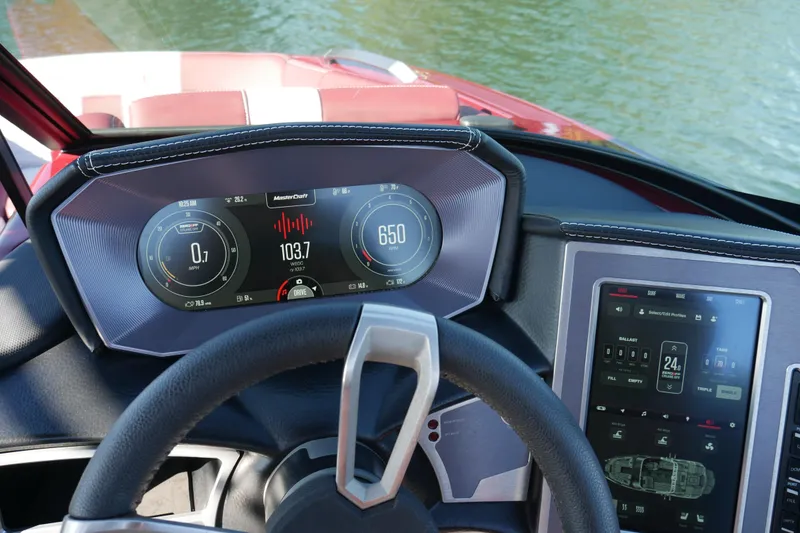 Slide: The Image of 2022 MasterCraft X22 dashboard with digital displays and control panel on water. - 10