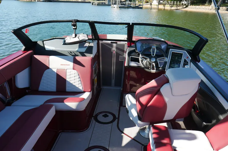 Slide: The Image of 2022 MasterCraft X22 boat interior with red and white seating, steering wheel, and control panel. - 13