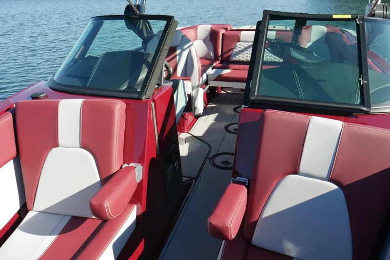 Slide: The Image of 2022 MasterCraft X22 boat interior with red and white seating on a sunny day. - 16