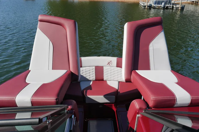 Slide: The Image of 2022 MasterCraft X22 boat interior with red and white seating on a lake. - 17