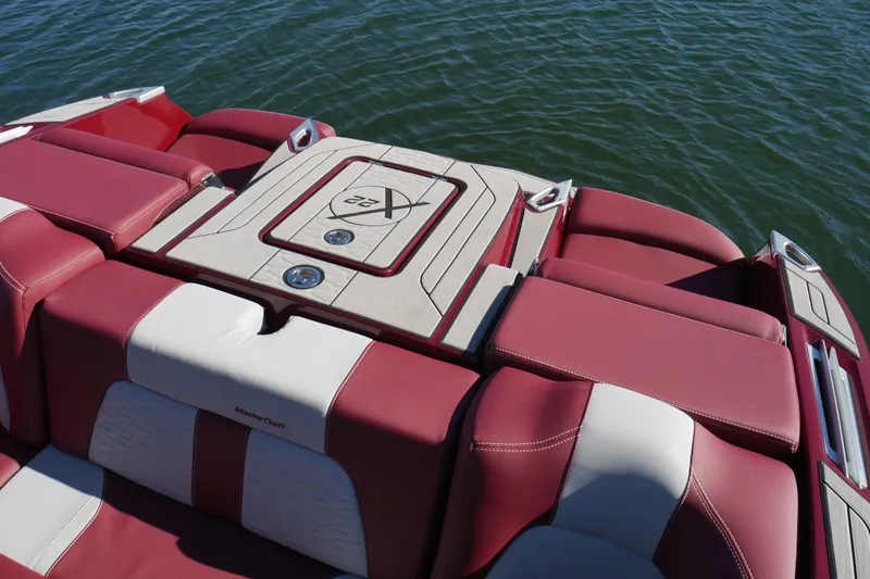 Slide: The Image of 2022 MasterCraft X22 boat with red and white seating on water. - 21