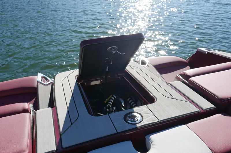 Slide: The Image of 2022 MasterCraft X22 boat with open storage compartment on a sunny lake. - 23