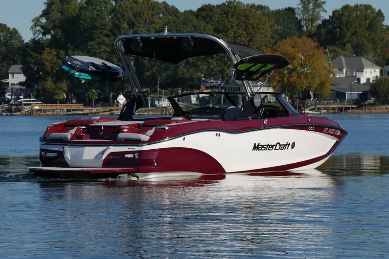 Slide: The Image of 2022 MasterCraft X22 boat on a calm lake with trees in the background. - 3