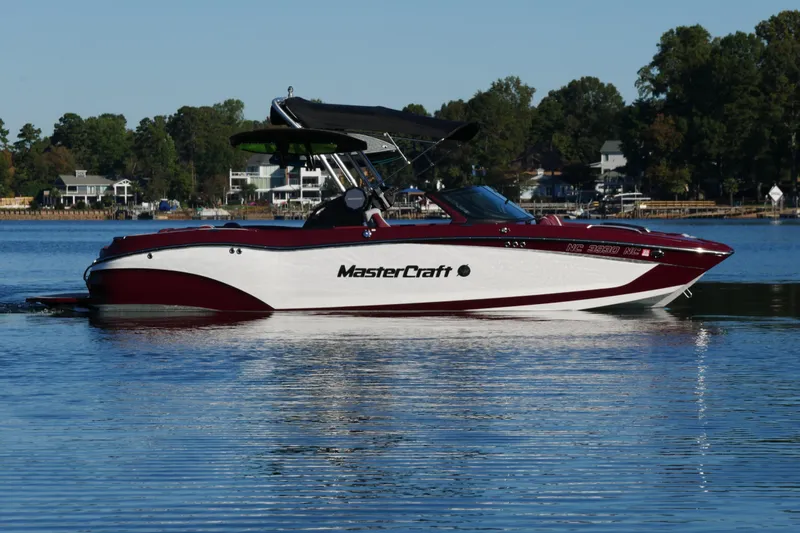 Slide: The Image of 2022 MasterCraft X22 boat on a calm lake with scenic background. - 4