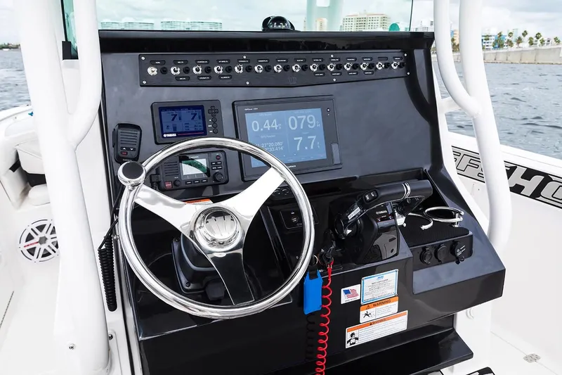 Slide: The Image of 2019 Wellcraft 262 Fisherman boat dashboard with steering wheel and navigation controls. - 60