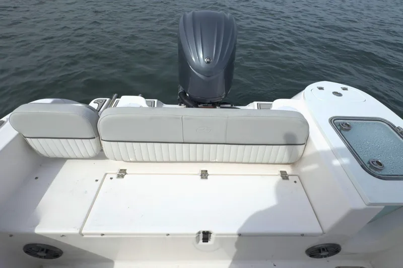 Slide: The Image of 2022 Sea Fox 248 Commander boat interior with seating and motor, on calm water. - 10