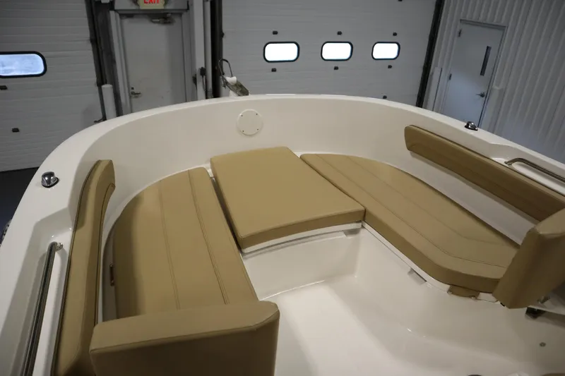 Slide: The Image of 2024 Bayliner Trophy T22CC boat interior with tan cushioned seating. - 11