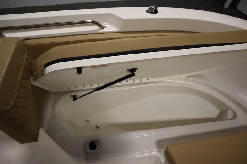 Slide: The Image of 2024 Bayliner Trophy T22CC boat storage compartment with open lid and cushioned seating. - 14