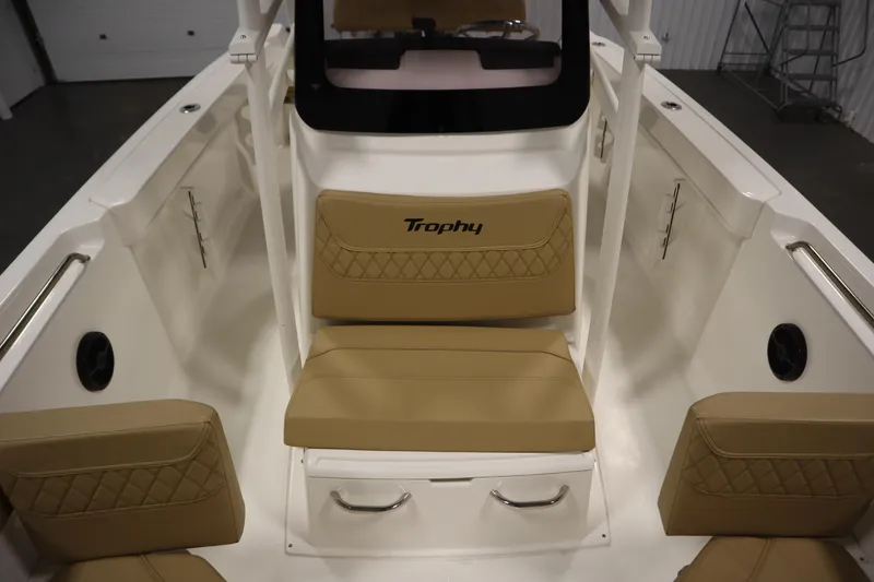 Slide: The Image of 2024 Bayliner Trophy T22CC boat interior with tan cushioned seating and storage compartments. - 15