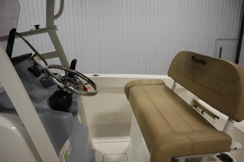 Slide: The Image of 2024 Bayliner Trophy T22CC boat interior with steering wheel and beige seating. - 23