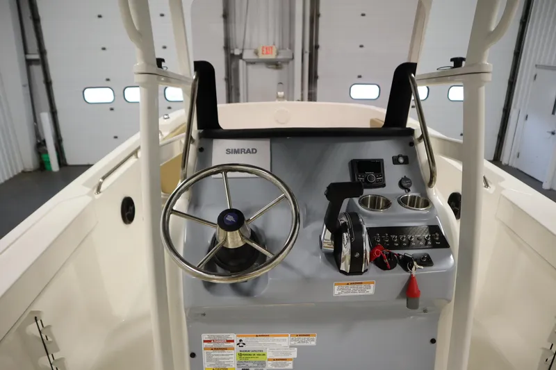 Slide: The Image of 2024 Bayliner Trophy T22CC boat console with steering wheel and controls. - 24