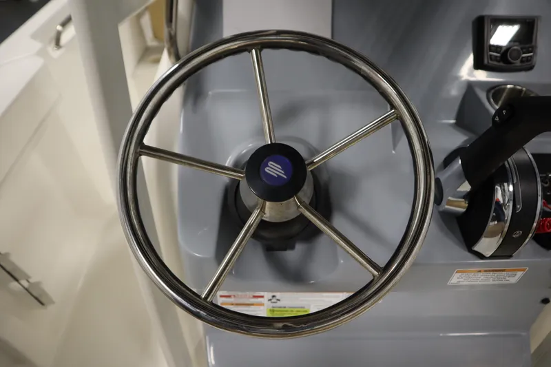 Slide: The Image of Steering wheel of 2024 Bayliner Trophy T22CC boat, featuring modern controls. - 25