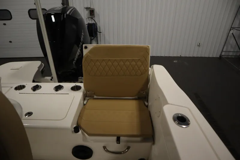 Slide: The Image of 2024 Bayliner Trophy T22CC boat interior with tan seating and Mercury engine. - 35