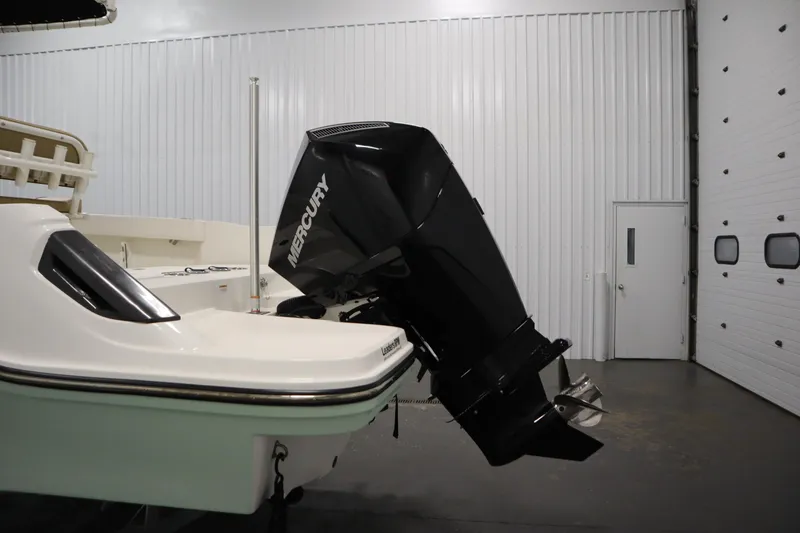 Slide: The Image of 2024 Bayliner Trophy T22CC with Mercury outboard motor in a garage setting. - 42