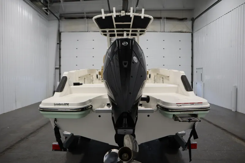 Slide: The Image of 2024 Bayliner Trophy T22CC boat in a garage, rear view with outboard motor. - 6