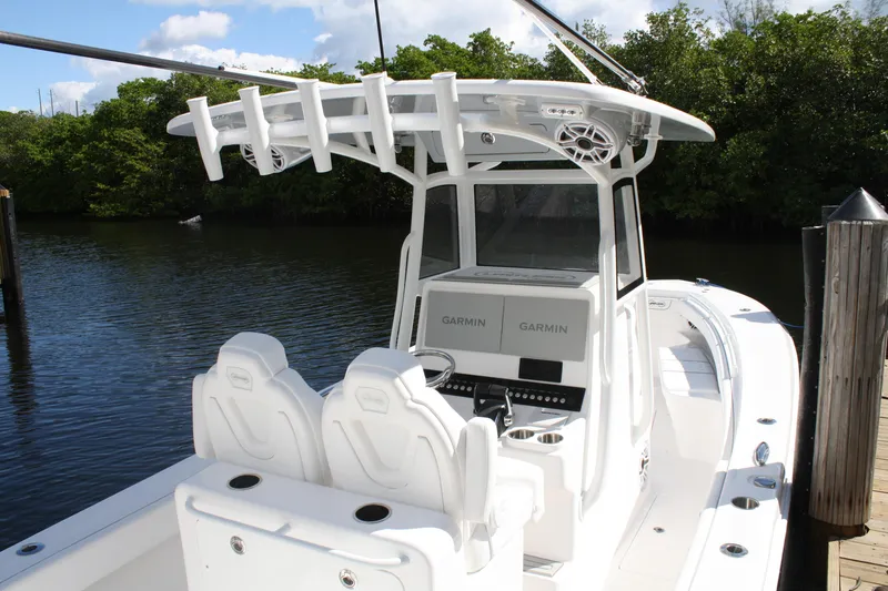 Slide: The Image of Limitless 270 boat, 2026 model, with dual Garmin displays, docked by lush greenery. - 17