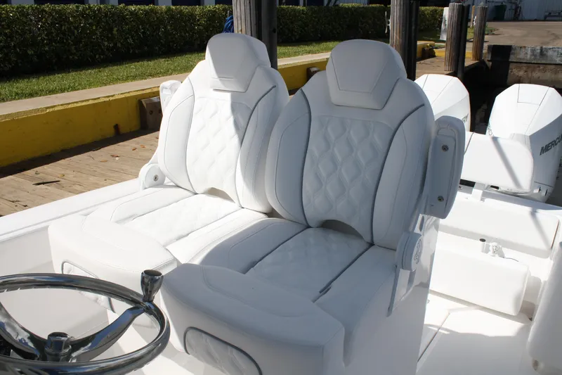 Slide: The Image of Luxurious white seating on Limitless 270 boat, 2026 model, with quilted design and steering wheel. - 20