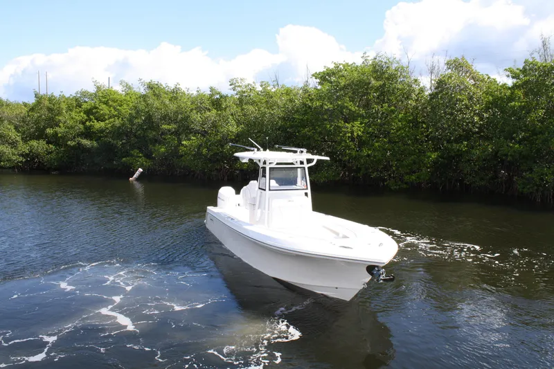 Slide: The Image of White Limitless 270 boat cruising on a calm river, surrounded by lush greenery, 2026 model. - 33