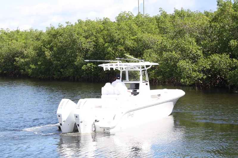 Slide: The Image of White Limitless 270 boat cruising on a calm river, surrounded by lush greenery, 2026 model. - 38